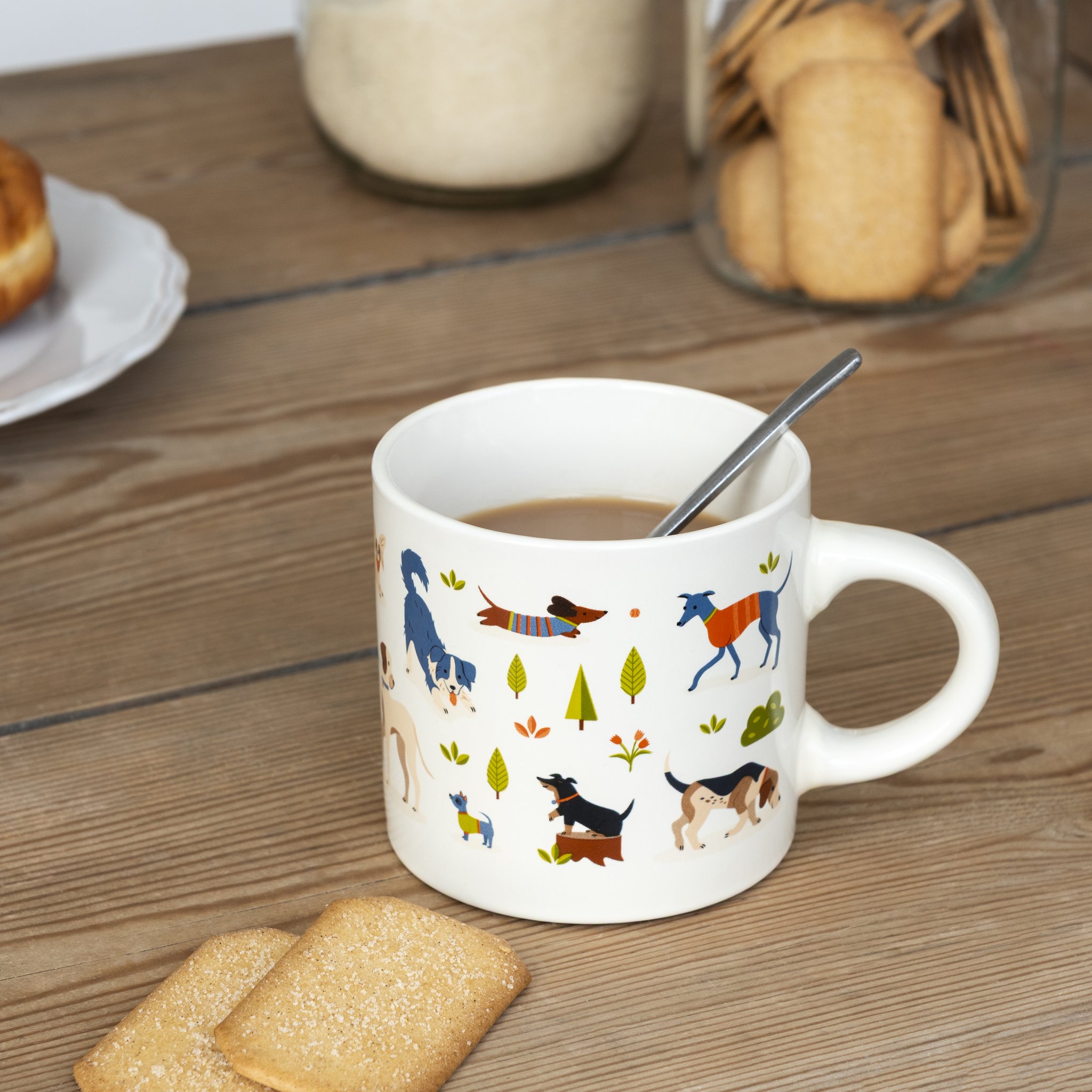 Tazza da caffè parco dei cani con caffè e cucchiaino sul tavolo di legno accanto a biscotti