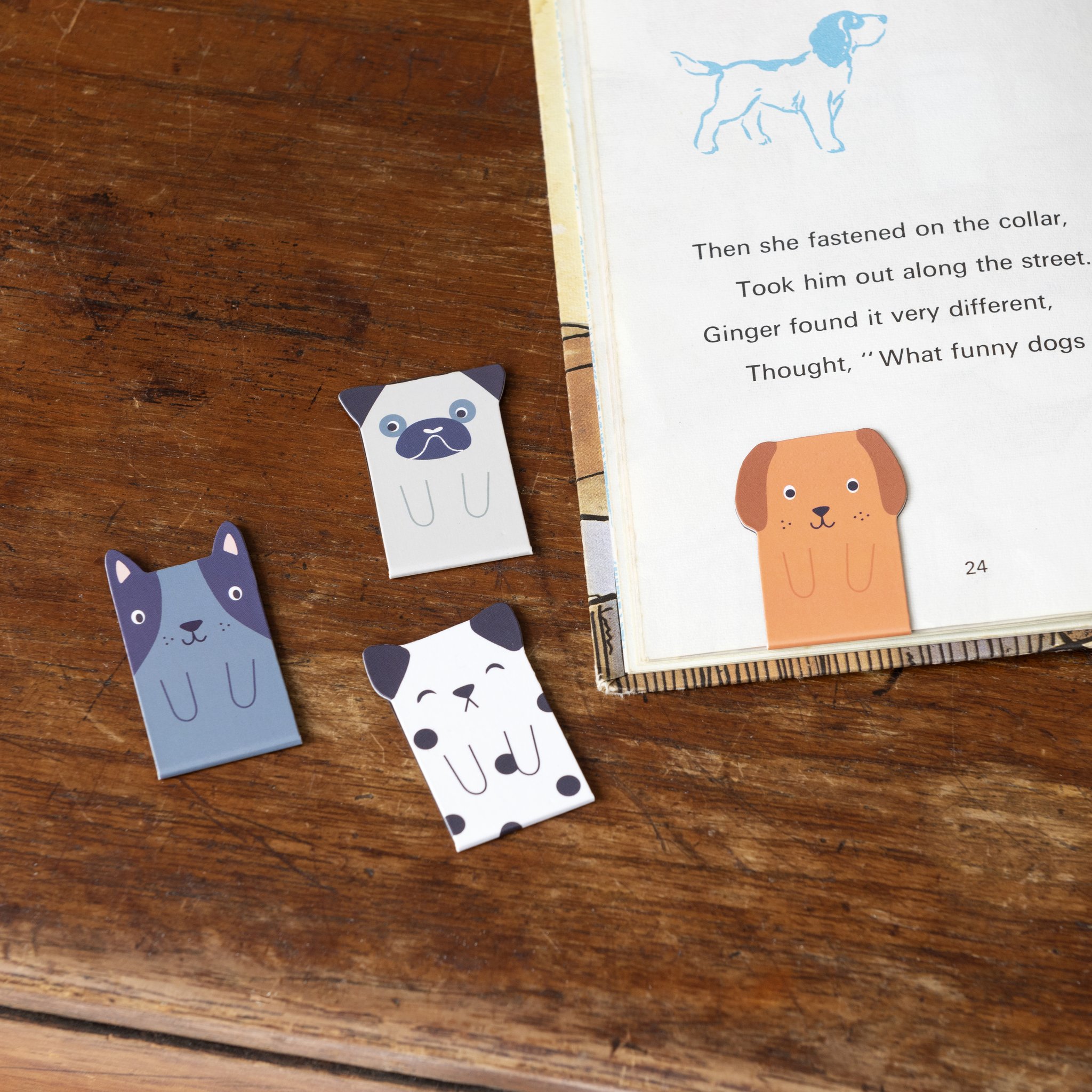 Hunde-Lesezeichen auf dem Holztisch neben einem Kinderbuch