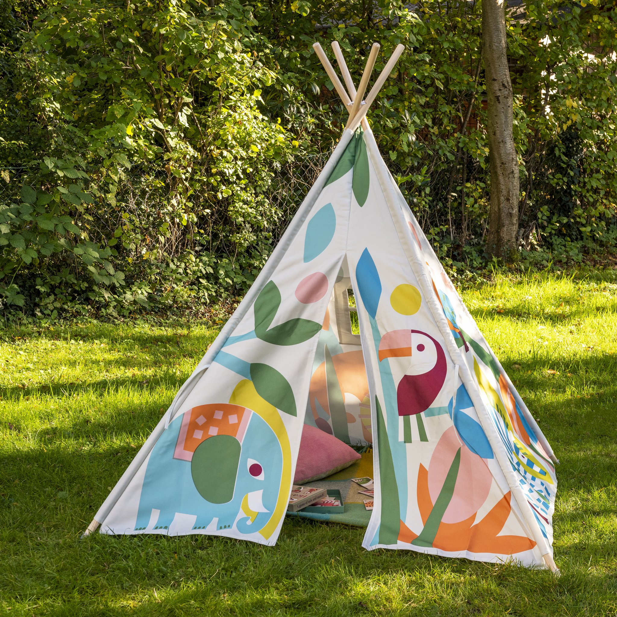 Kind spielt im Wild Wonders Kinderzelt auf der Gartenwiese