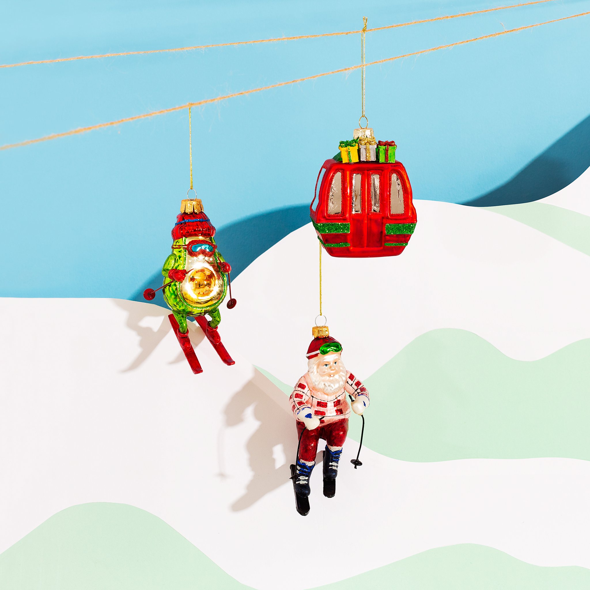 Gondola Christmas decoration on a cable above a ski slope with skier ornaments