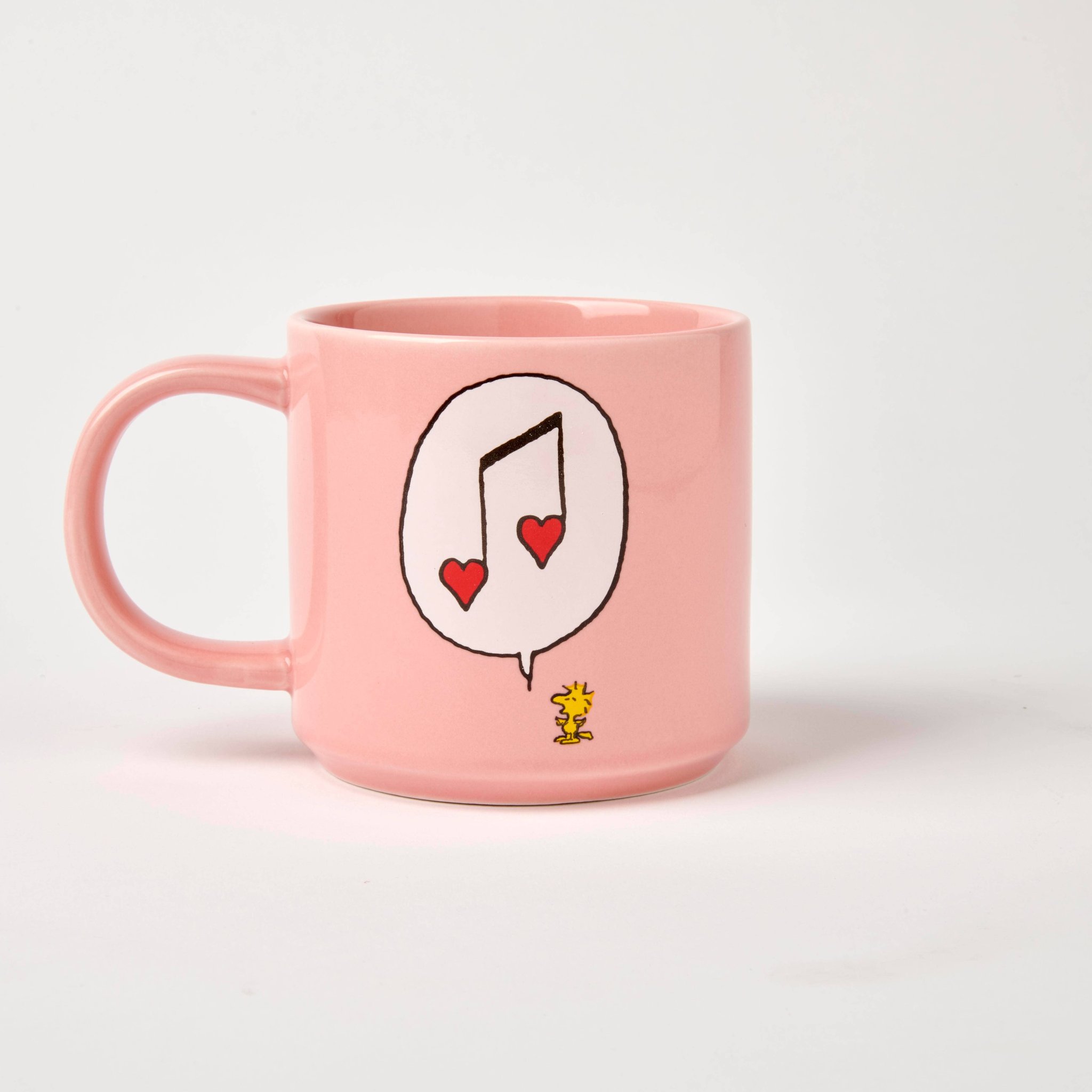 Rückseite der rosa Snoopy-Tasse mit Sprechblase, Musiknote aus Herzen und Woodstock