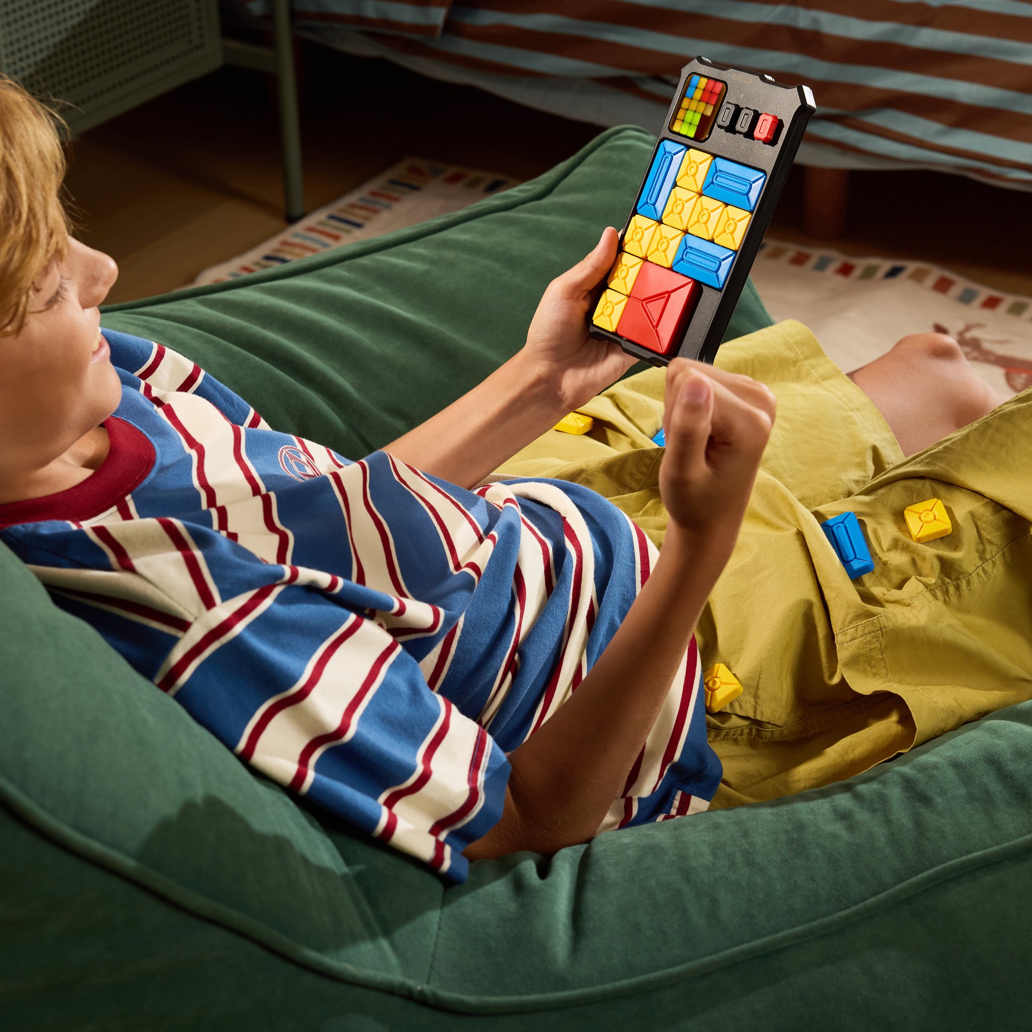 Relaxing on the sofa, a boy is absorbed in a level on the Super Slide sliding puzzle.
