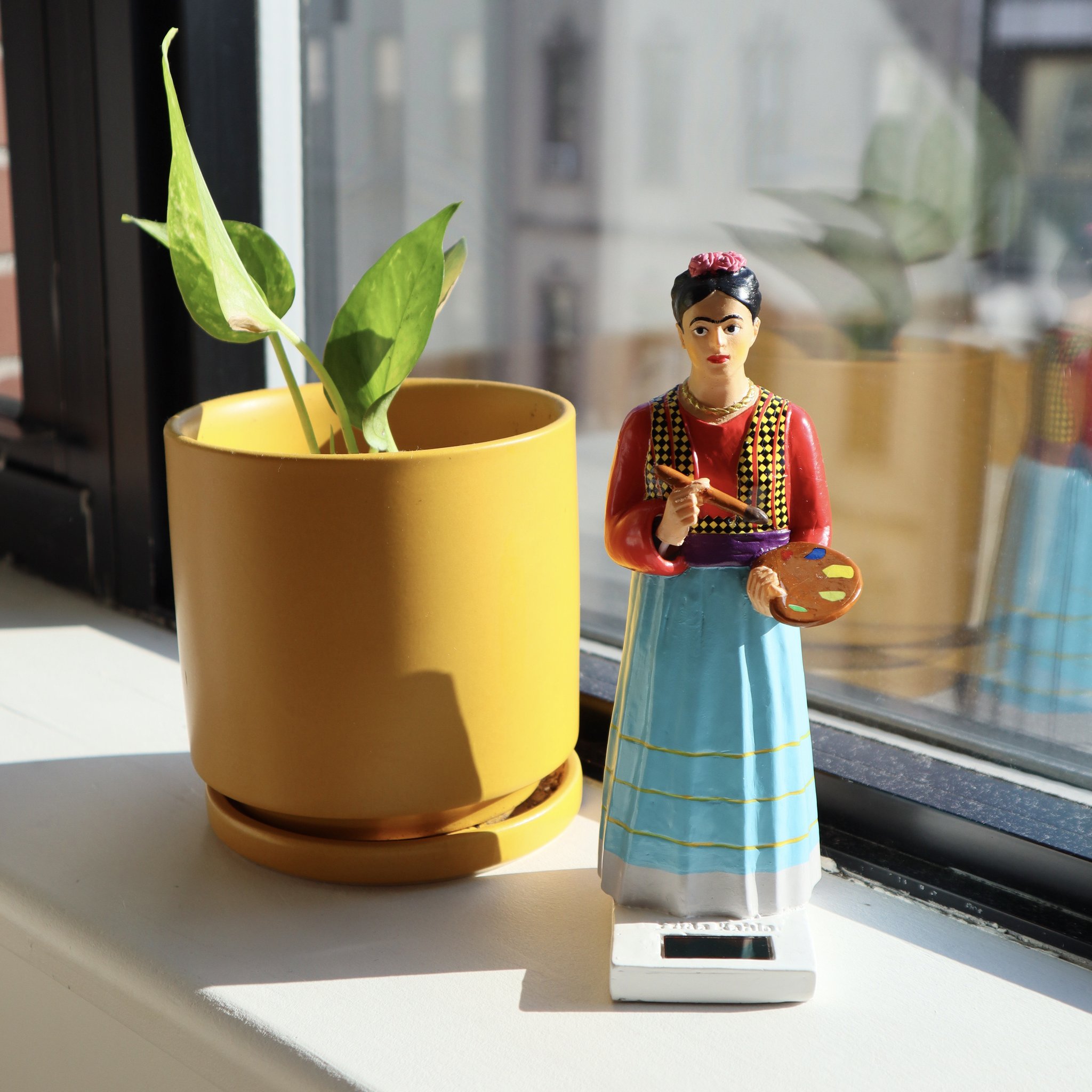 Frida Kahlo solaire avec palette et pinceau sur le rebord de fenêtre