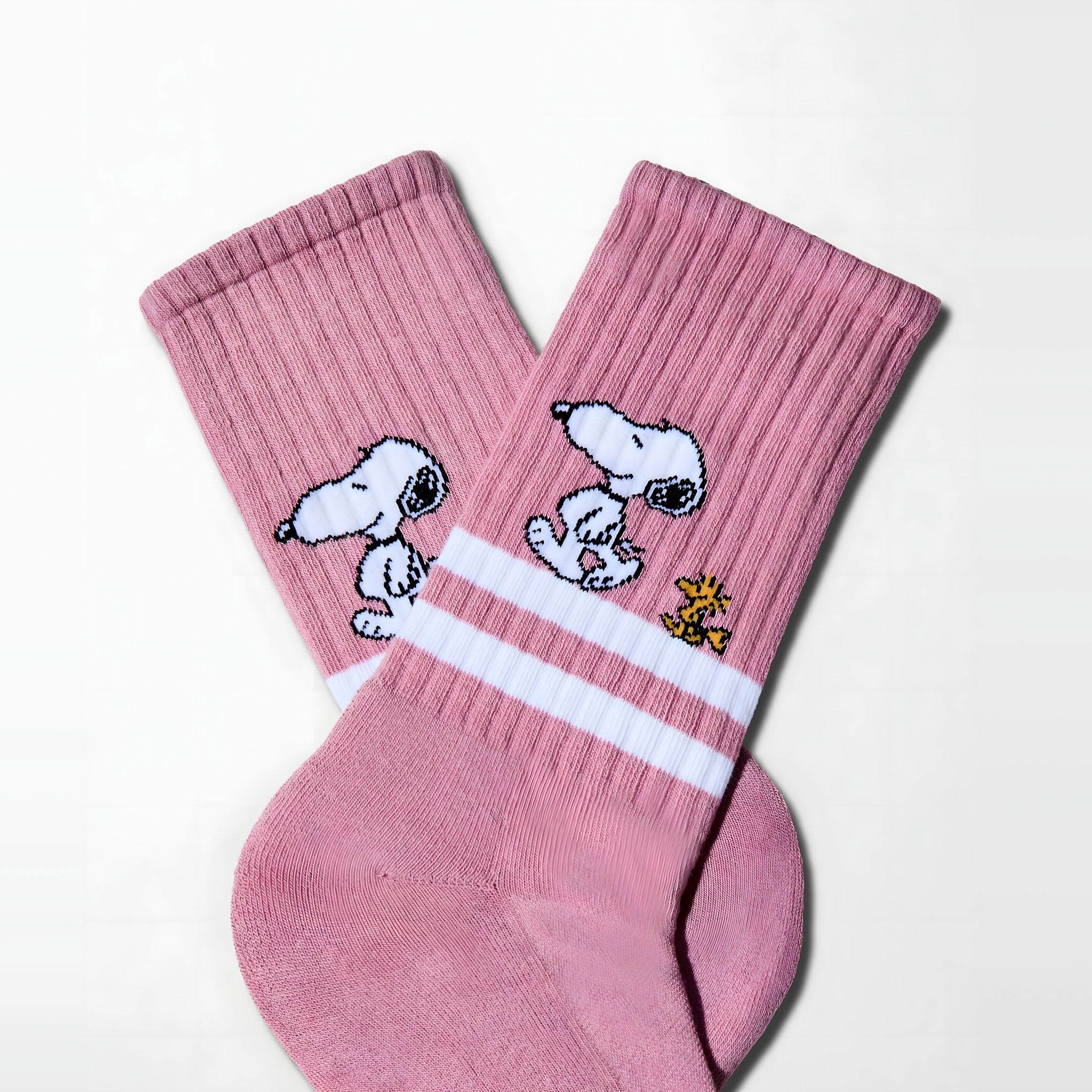 Pink Snoopy tennis socks side by side, leg with two white stripes and knitted Snoopy