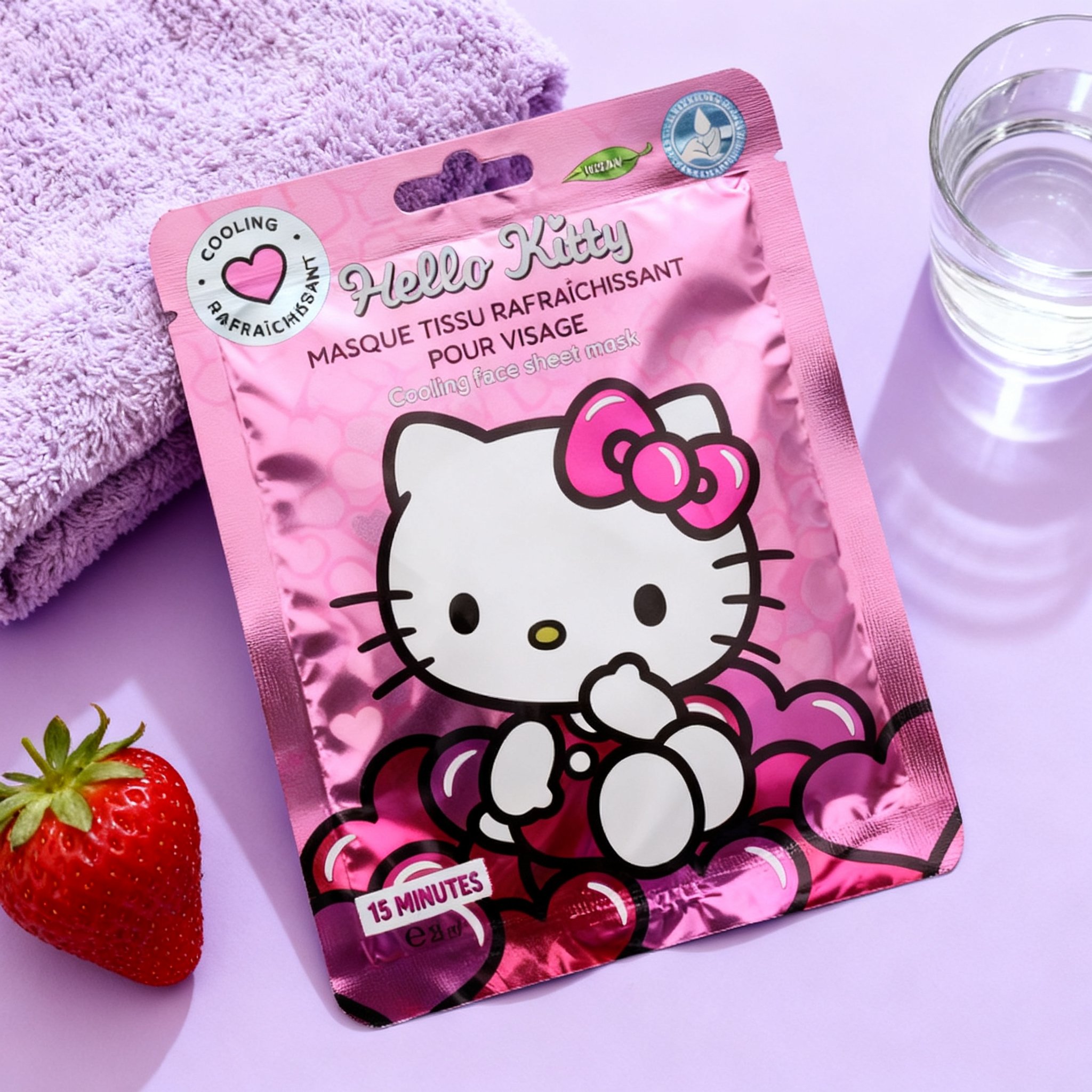 Hello Kitty sheet mask on a lilac surface with a strawberry, towel and glass of water