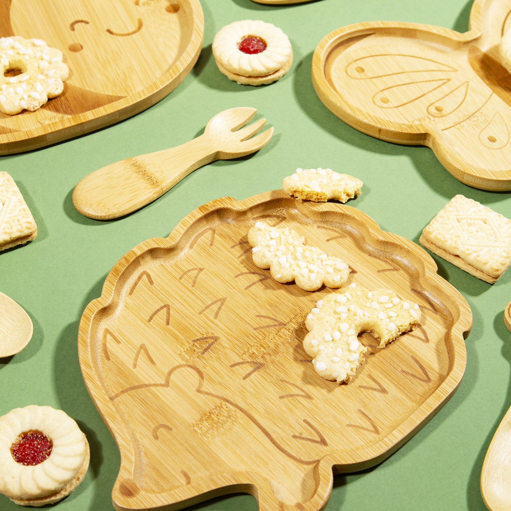 Hedgehog kids plate with biscuits and bamboo spoons on a green table