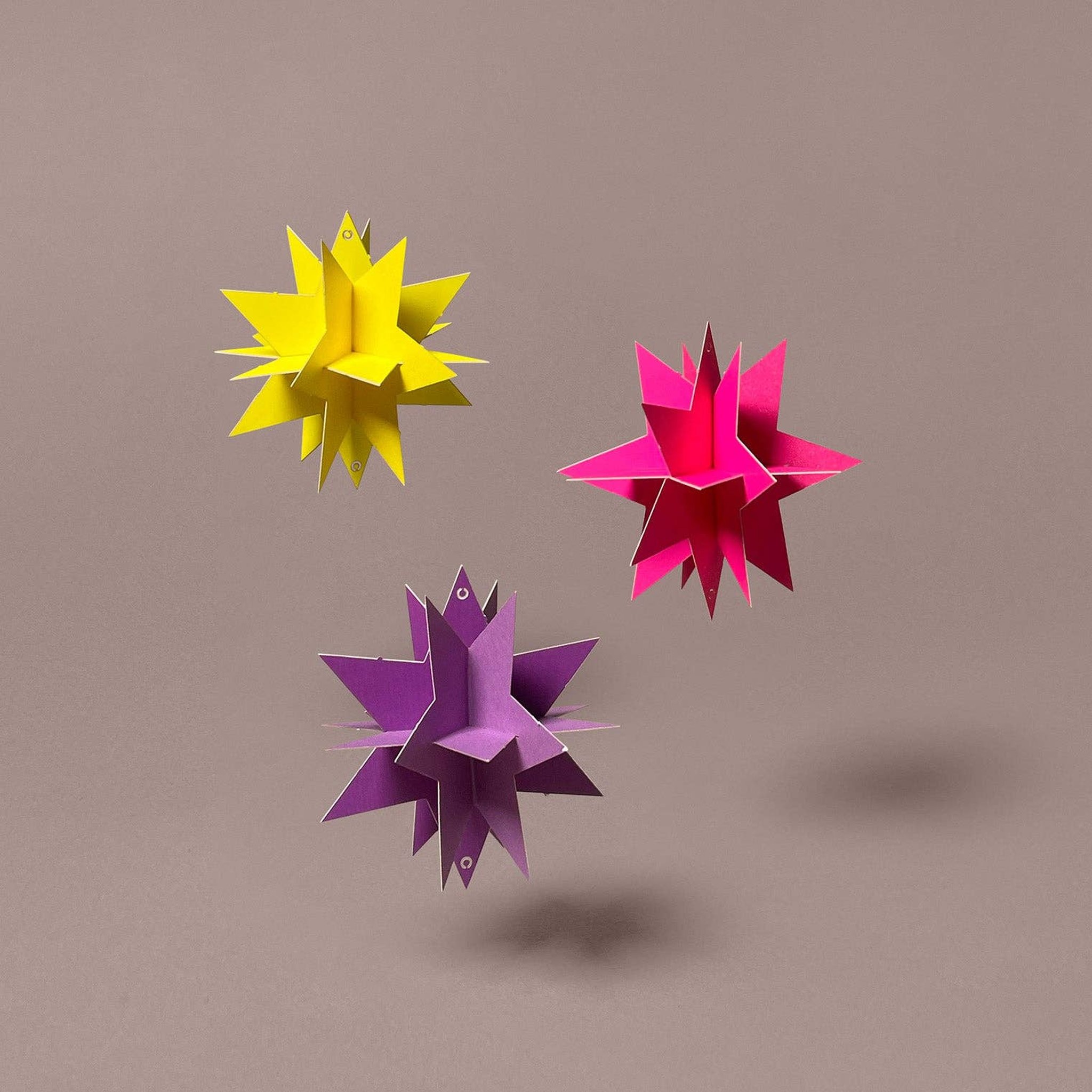 Fertig gebastelt: 3D-Modell drei Sterne in Neonpink, Neongelb und Violett aus Papier