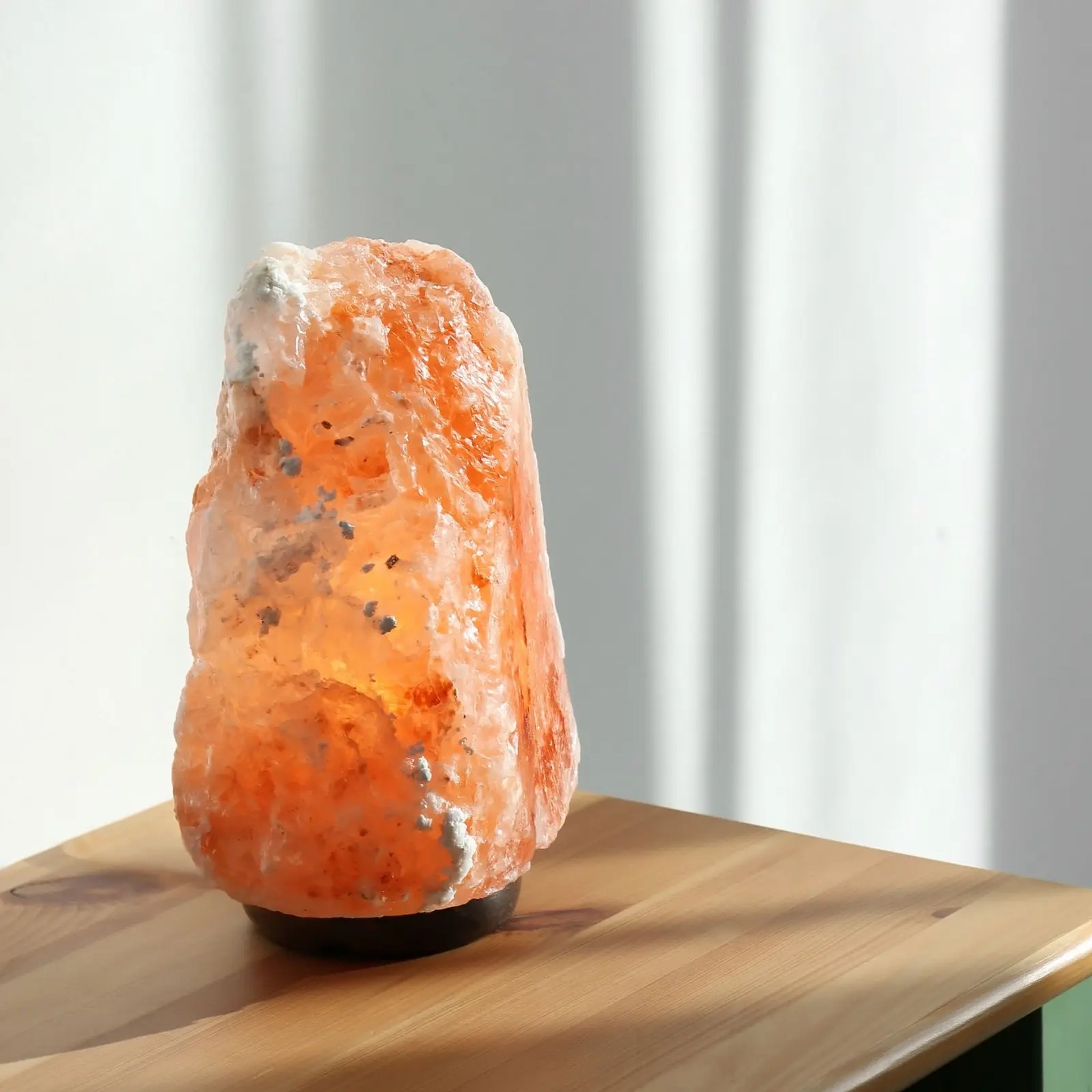 Salt lamp made from a hand-carved block of Himalayan salt on a wooden base