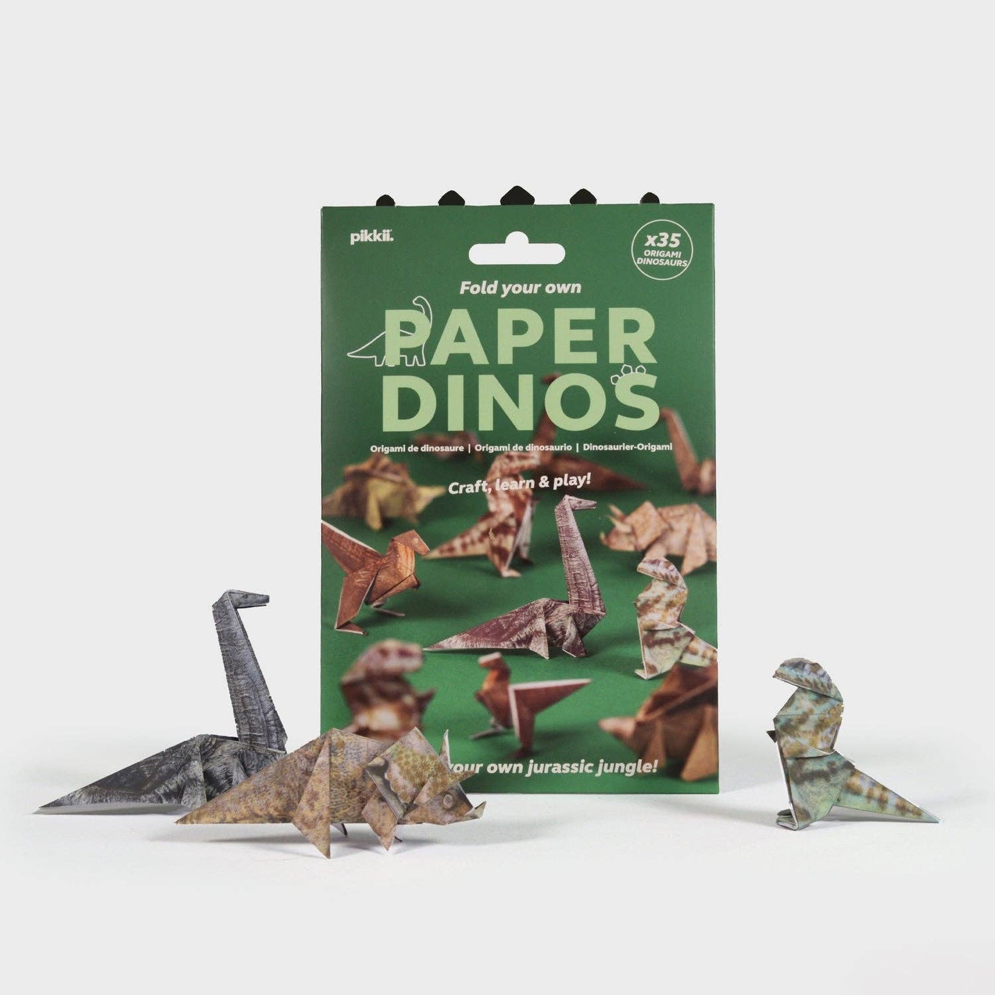 Paper Dinos origami kit in its pack with folded paper dinosaurs beside it