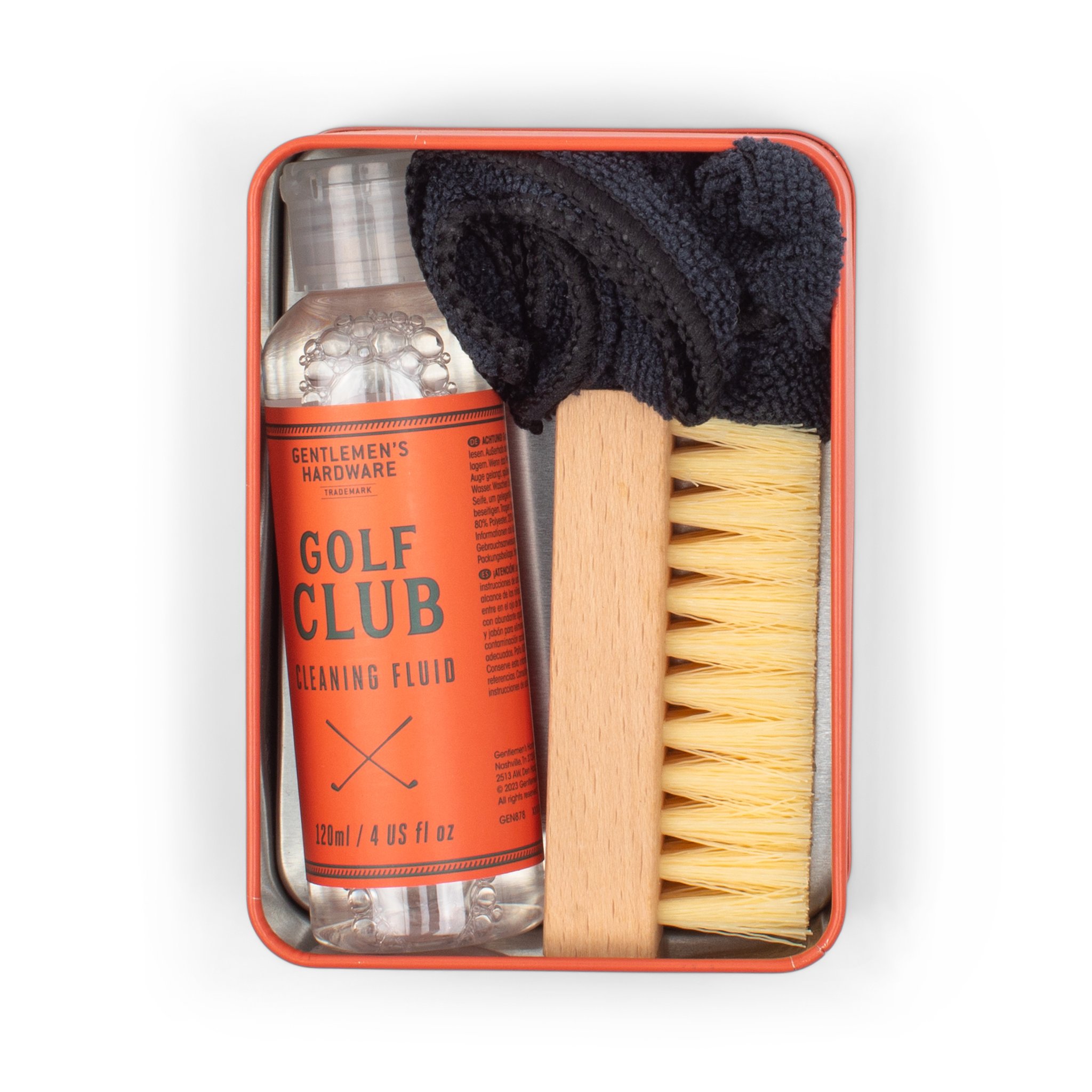 Open tin from above holding the cleaning fluid bottle, a wooden brush and a folded black cloth