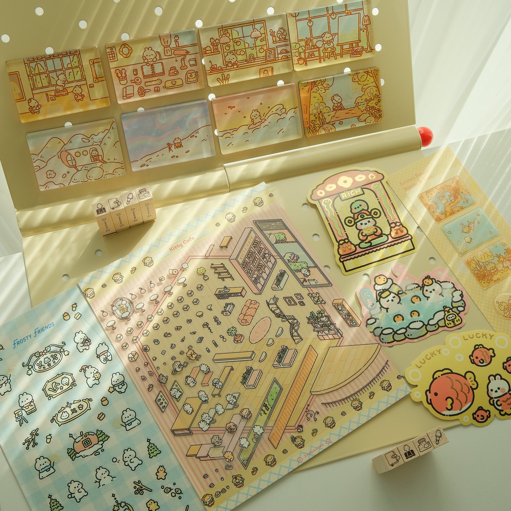 The Kitty Cafe sticker sheet on a desk, surrounded by other stationery items