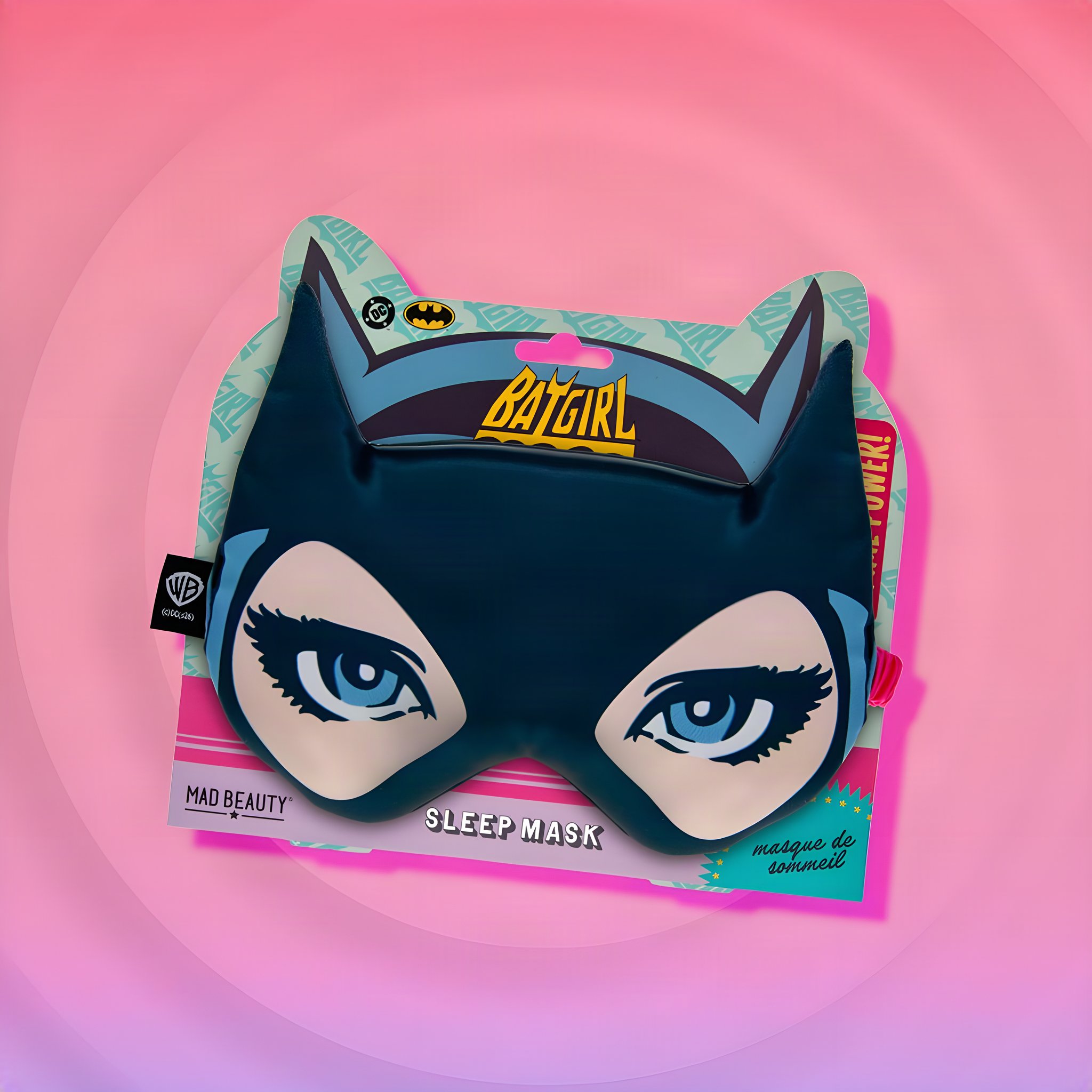 Batgirl Satin-Schlafmaske mit Katzenohren und grossen Comic-Augen auf der Verpackungskarte vor rosa Kreisen