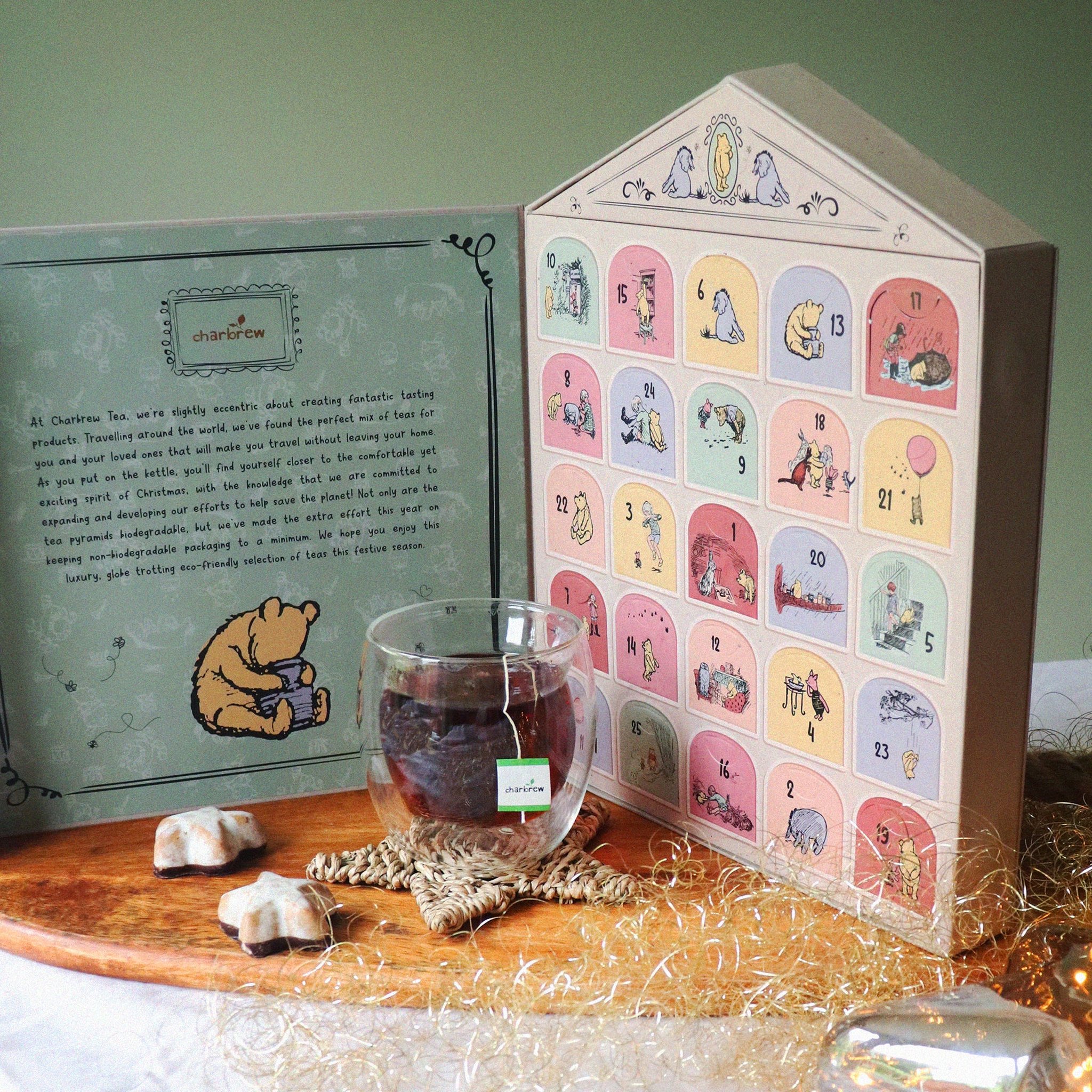 Calendario dell'Avvento Winnie the Pooh aperto sul tavolo accanto a una tazza di tè