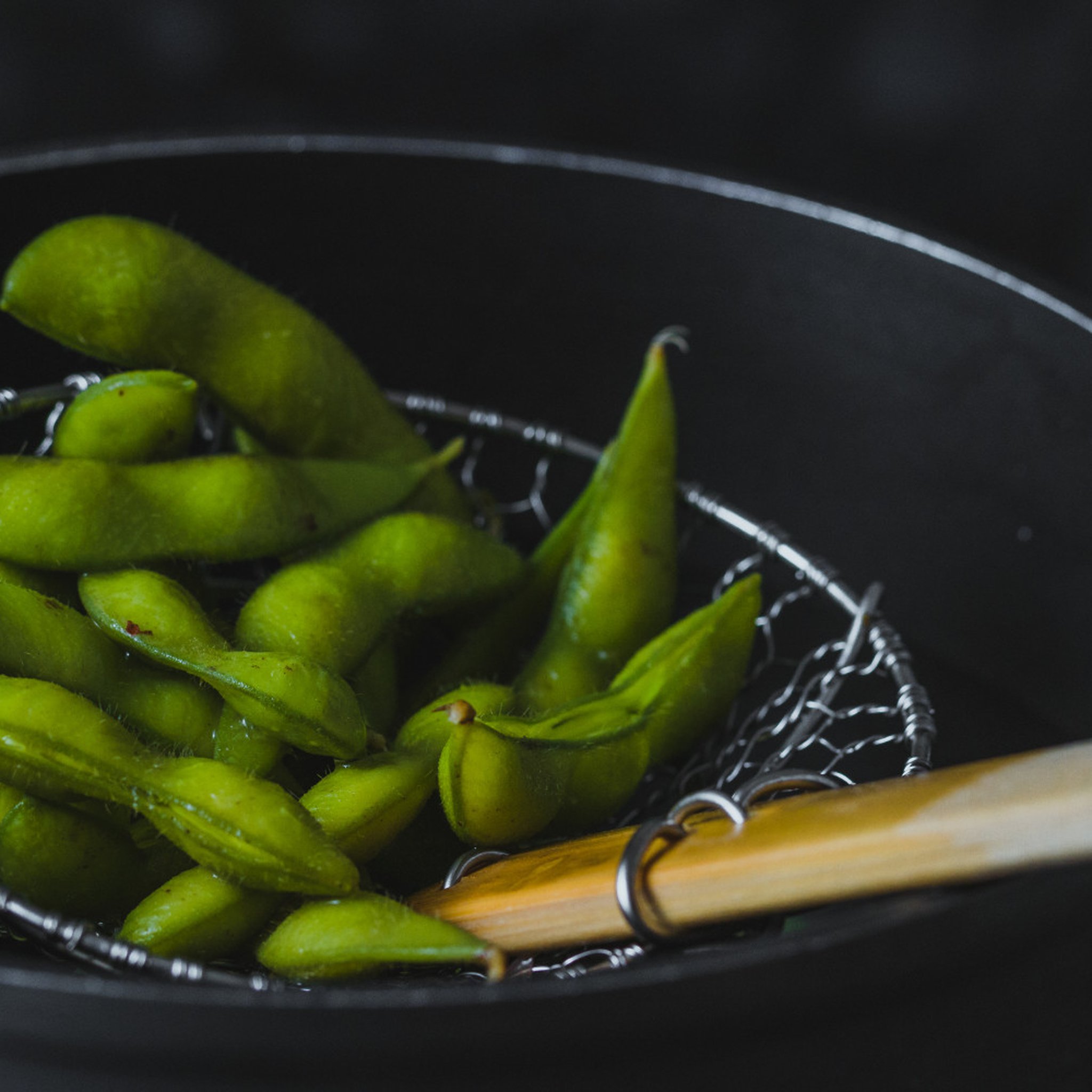 Edamame im Bambus Schaumkelle über Wok