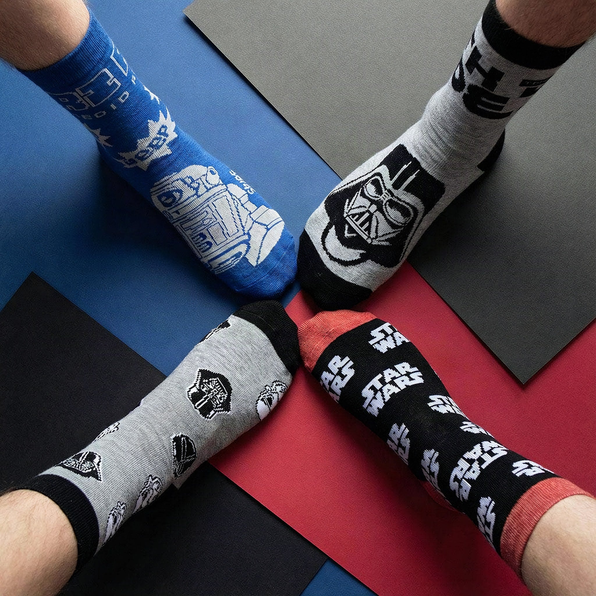 Four people wearing Star Wars crew socks with their feet arranged in a star
