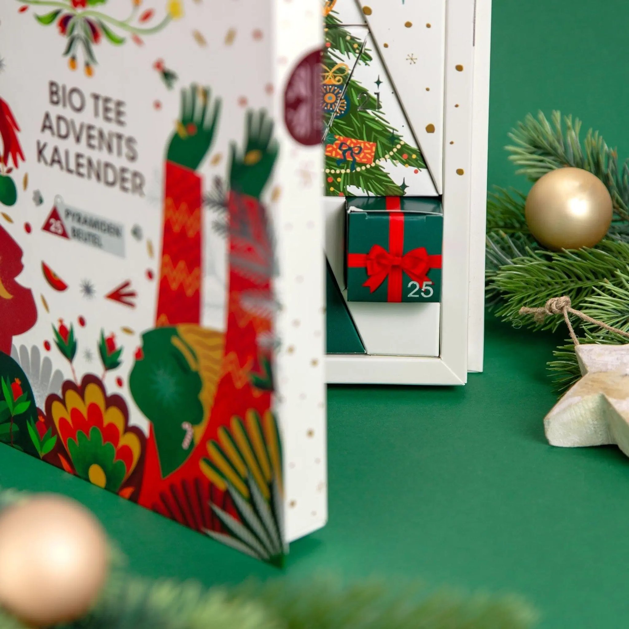 Half-open organic tea advent calendar showing cover and inside, with Christmas decorations