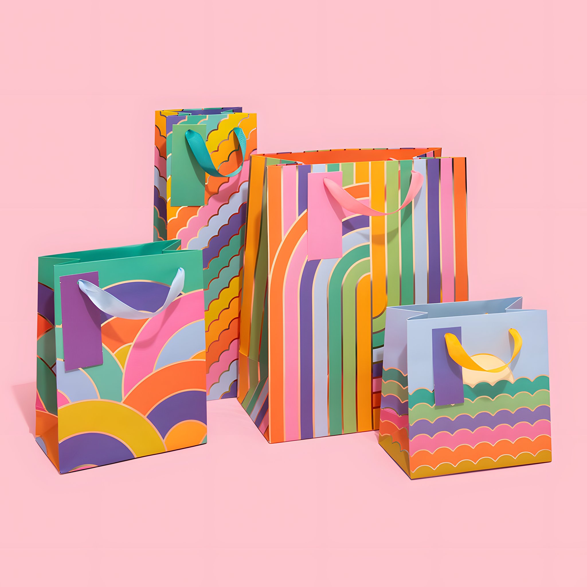 Busta regalo media con archi arcobaleno insieme ad altre buste regalo Ohh Deer su sfondo colorato