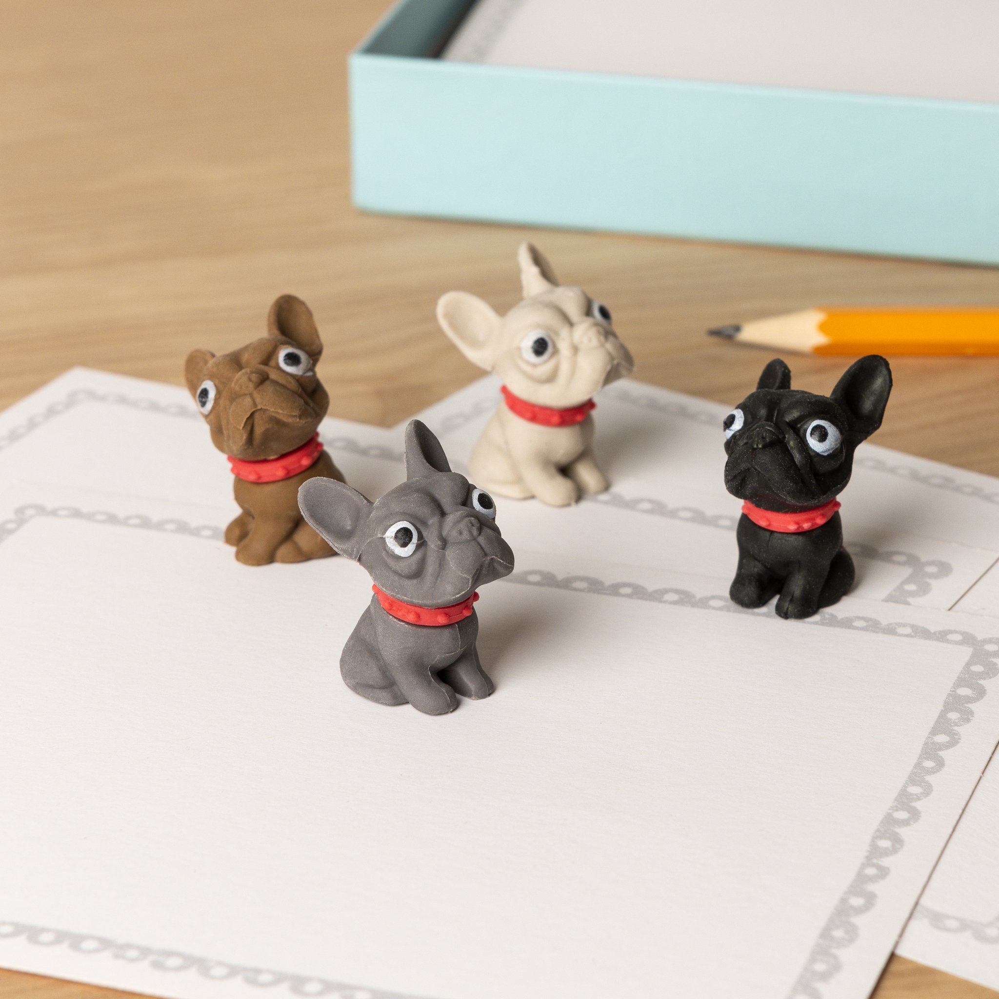 Gomme bulldog francese: quattro bulldog con collare rosso su carta con matita