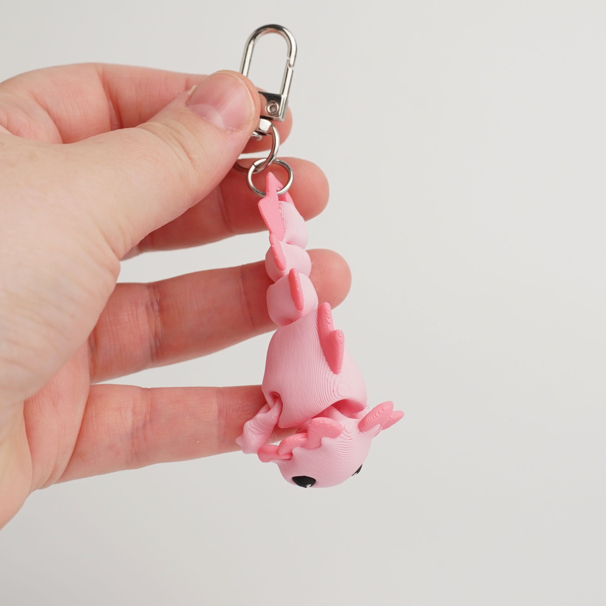 Tukitsu Axolotl Schlüsselanhänger Rosa — in der Hand mit Karabiner