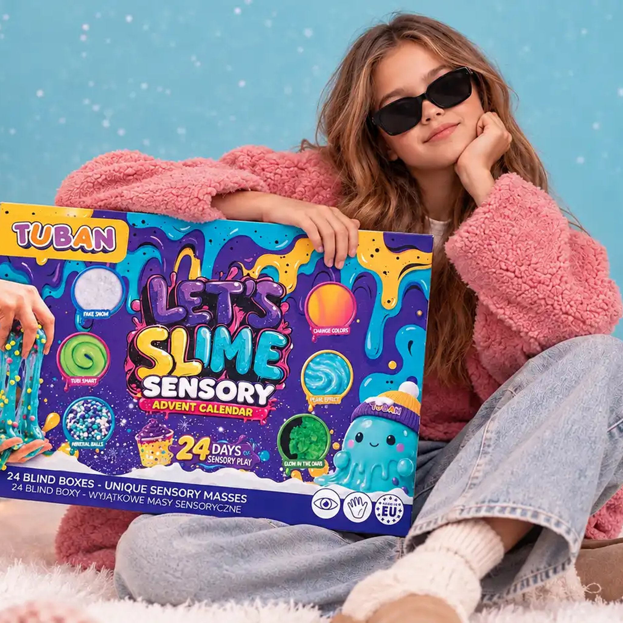Mädchen sitzt vor dem Christbaum und hält den Slime-Adventskalender Let's Slime im Arm