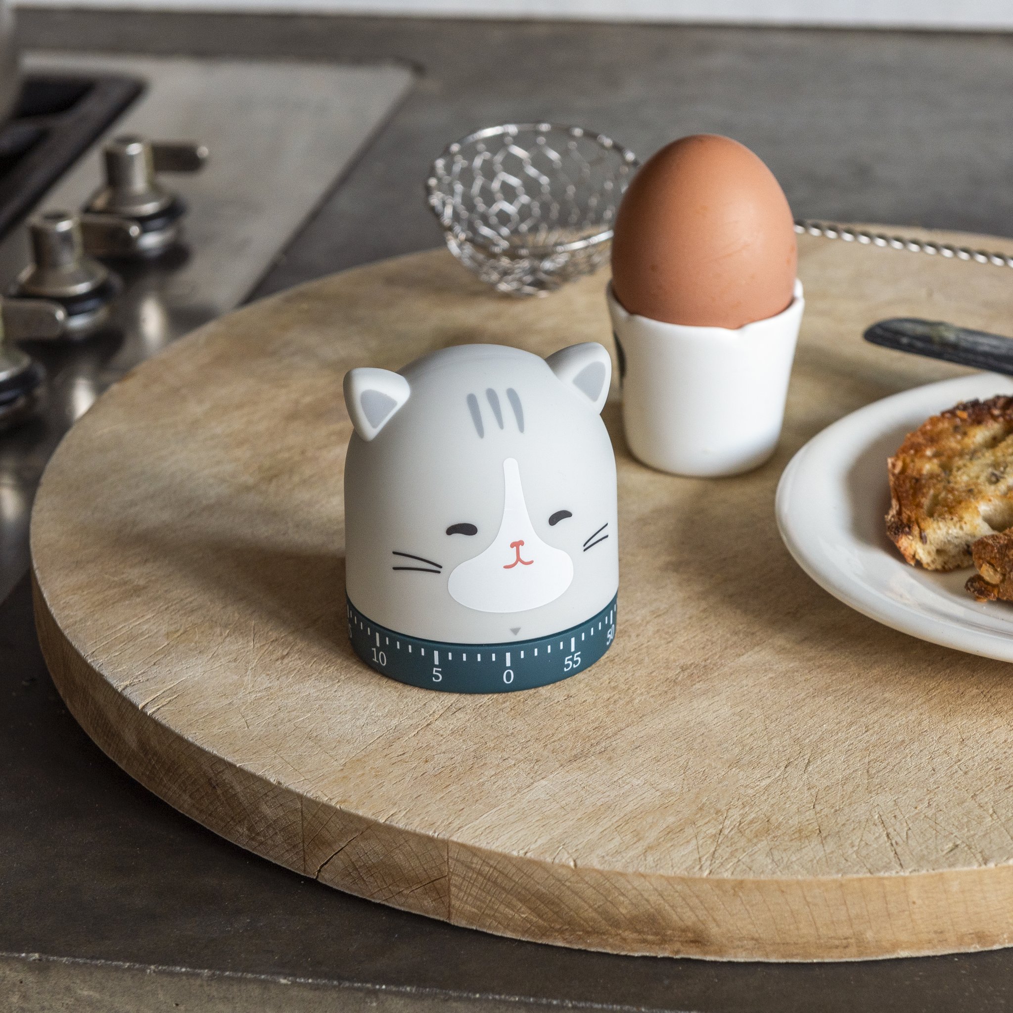 Minuteur de cuisine chat sur la planche en bois à côté d'un œuf