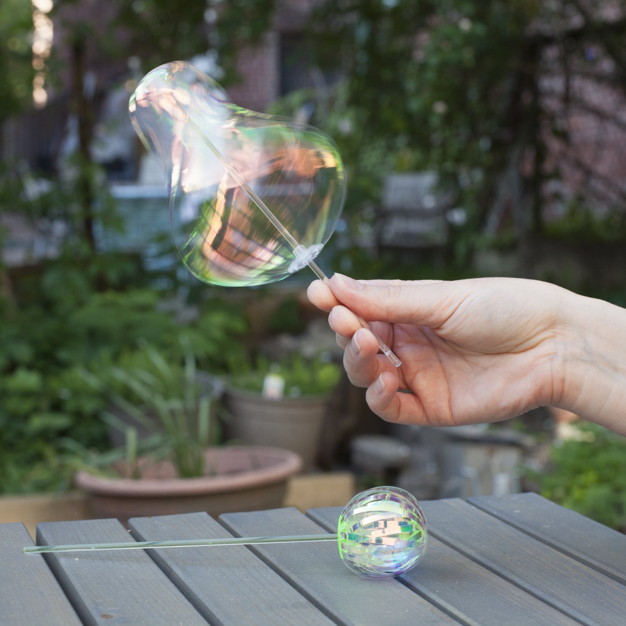 Rainbow Twirler in mano, sfera iridescente che gira in giardino