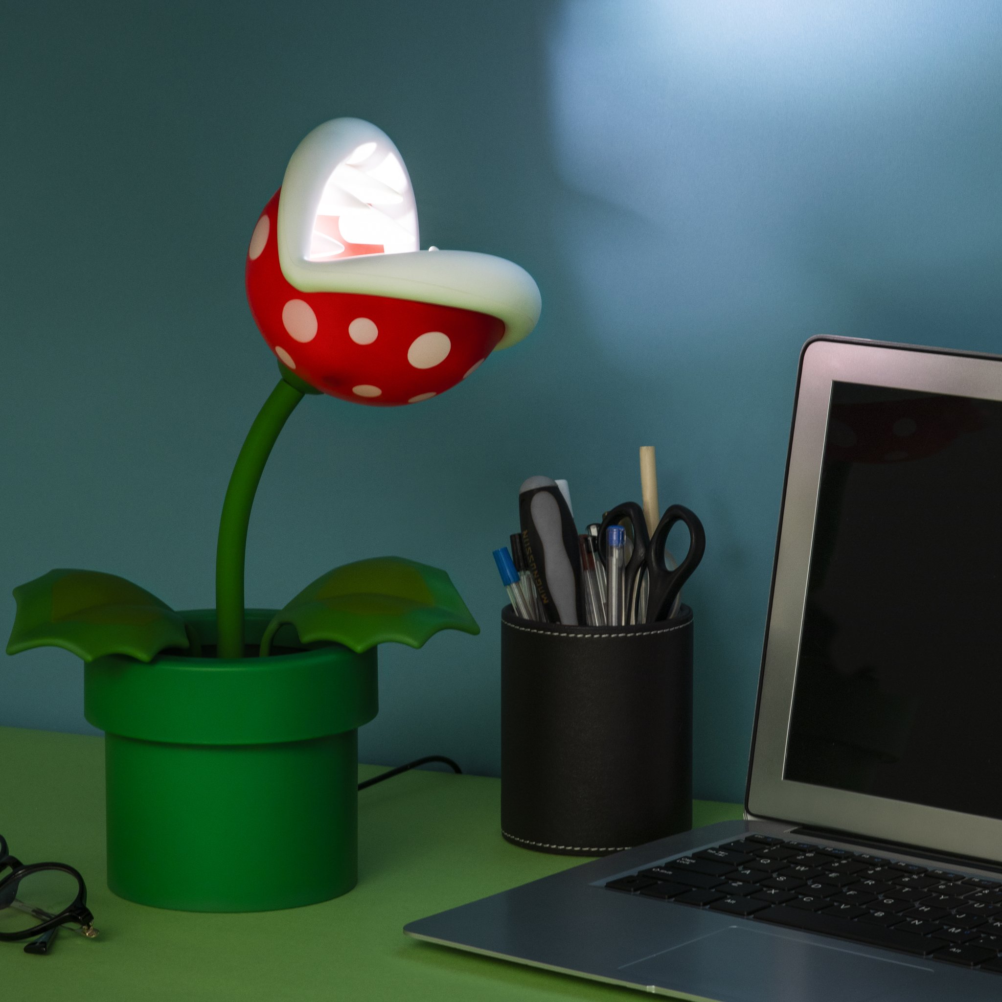 Piranha-Pflanzen-Lampe auf einem Schreibtisch neben einem Laptop
