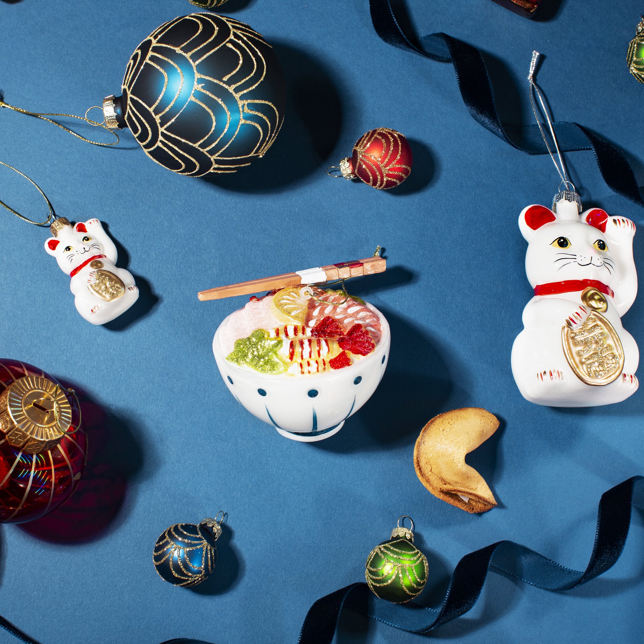 Décoration de sapin chat porte-bonheur à côté d'ornements bol de nouilles et biscuit chinois
