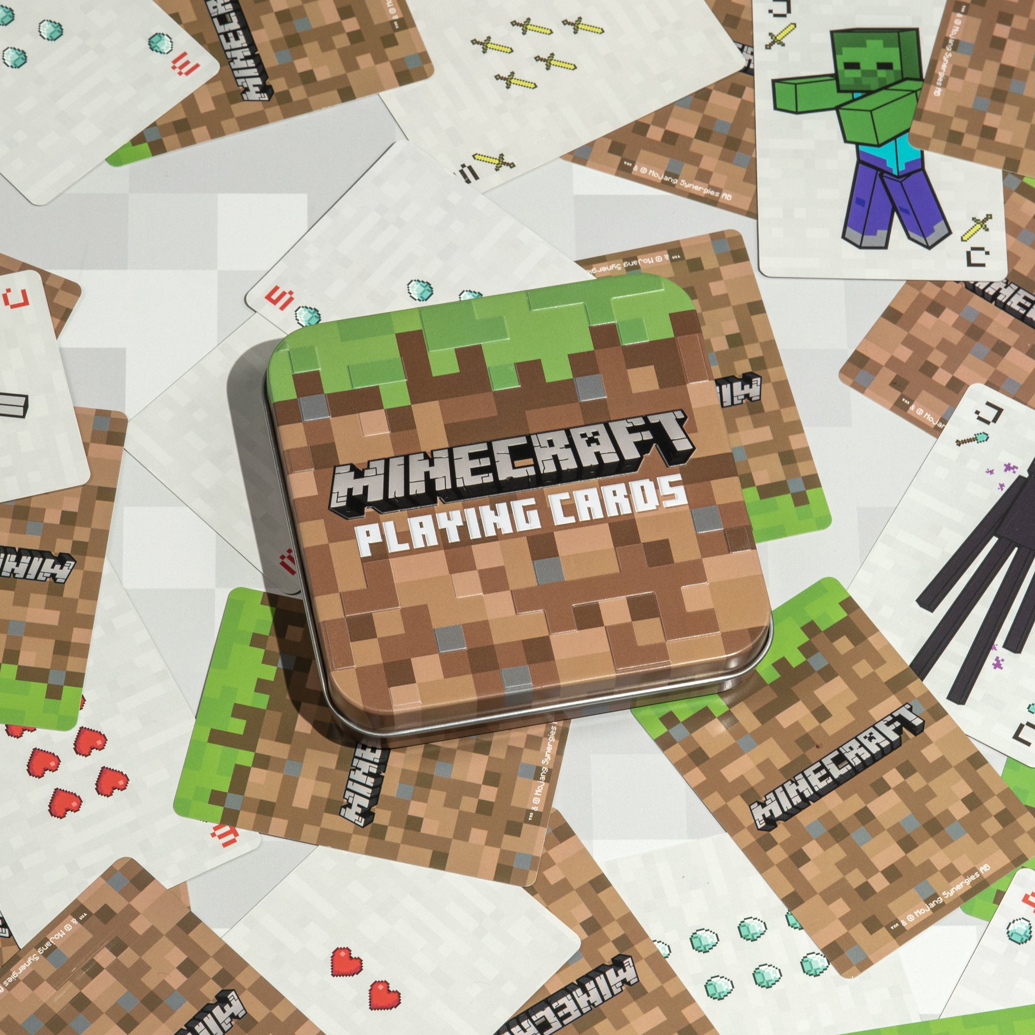 Cartes à jouer Minecraft dans leur boîte métallique sur des cartes étalées