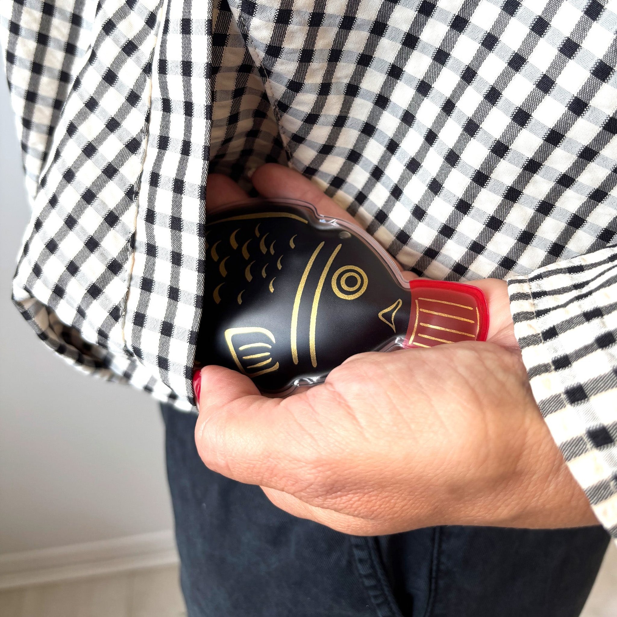 Soy sauce hand warmer slipped into a checked shirt pocket