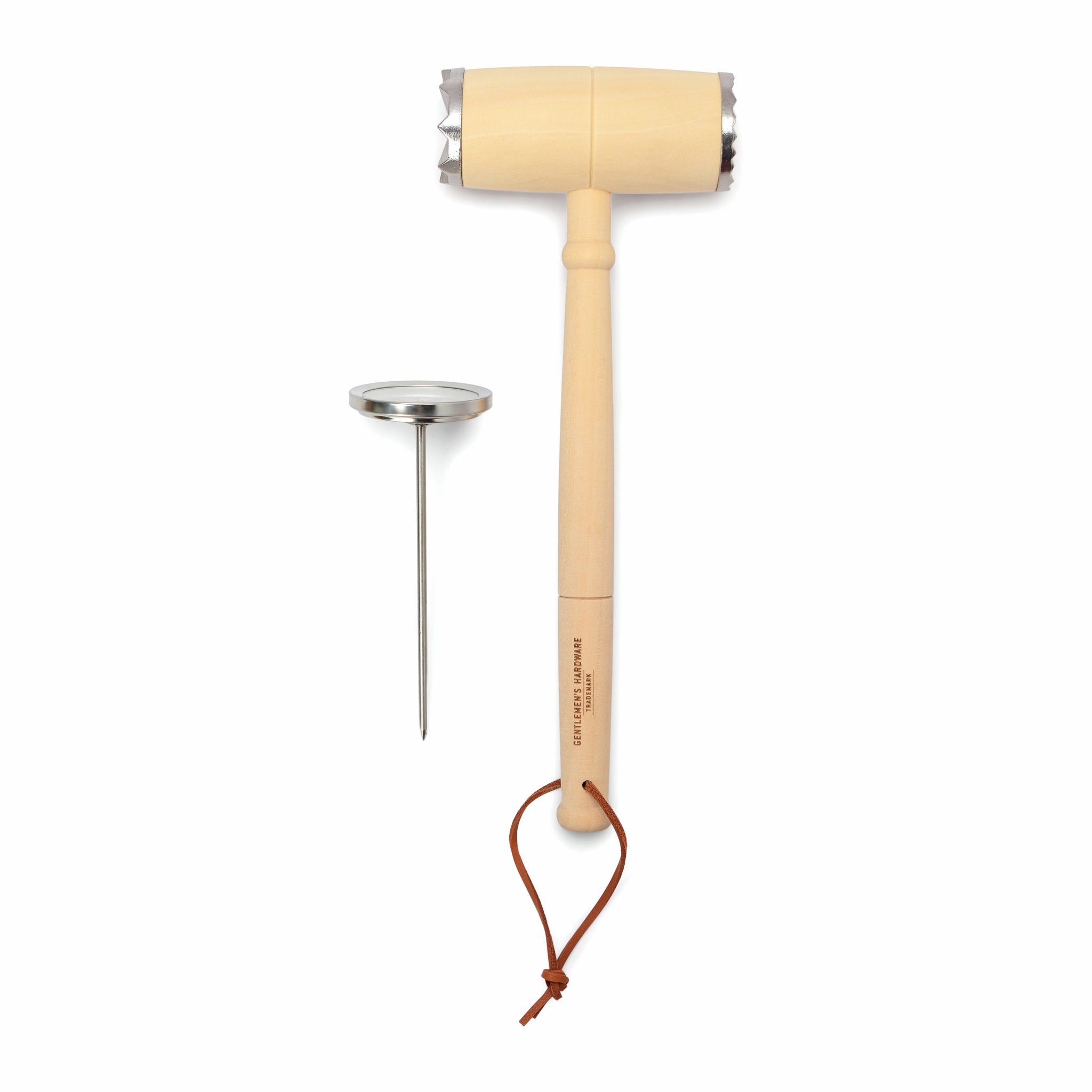 BBQ Lovers Kit on white: light wooden meat tenderizer with leather loop lying beside the meat thermometer